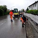 Straßenbauer Heiko Gobig und Ralf Klein beim Setzen einer Wasserführungsrinne