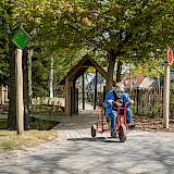 Kind auf Dreirad augf inklusivem Spielplatz