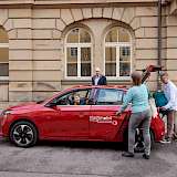 Drei Persone an einem Carsharing Fahrzeug